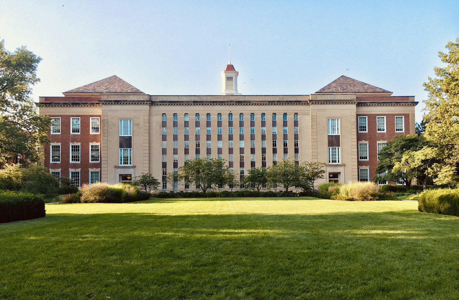 A university campus framed by green trees